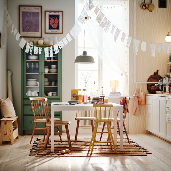 Bright kitchen with white HAUGA table in center with chairs around.