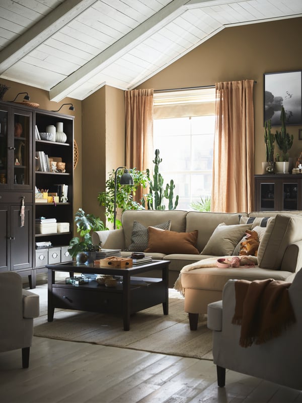 Ein Ecksofa EKHOLMA und ein Couchtisch IDANÄS stehen in der Mitte eines traditionellen Wohnzimmers mit Holzboden.