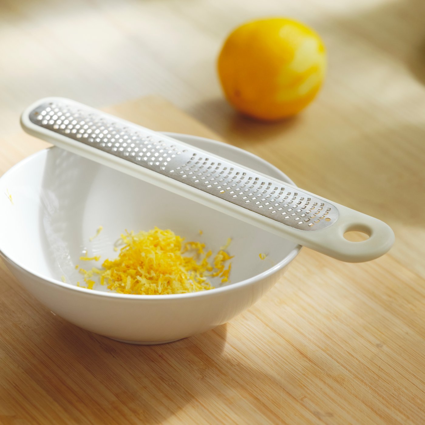 An off-white UPPFYLLD handheld grater