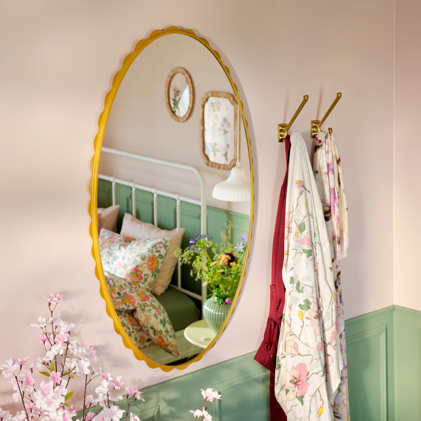 Een donkergele DAGGKAPRIFOL-spiegel weerspiegelt een gezellige slaapkamer met bloemendecor en een bed dat is versierd met zachte kleuren.