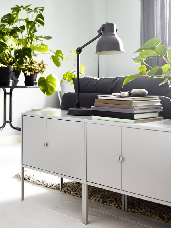 A dark grey HEKTAR work lamp with wireless charging in the living room