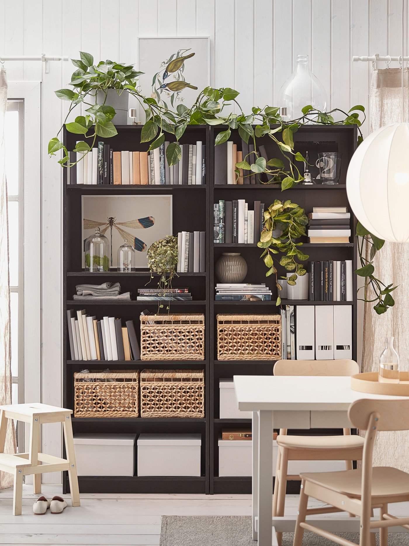 Bookcase with various decoration and storage details, behind the dining table.