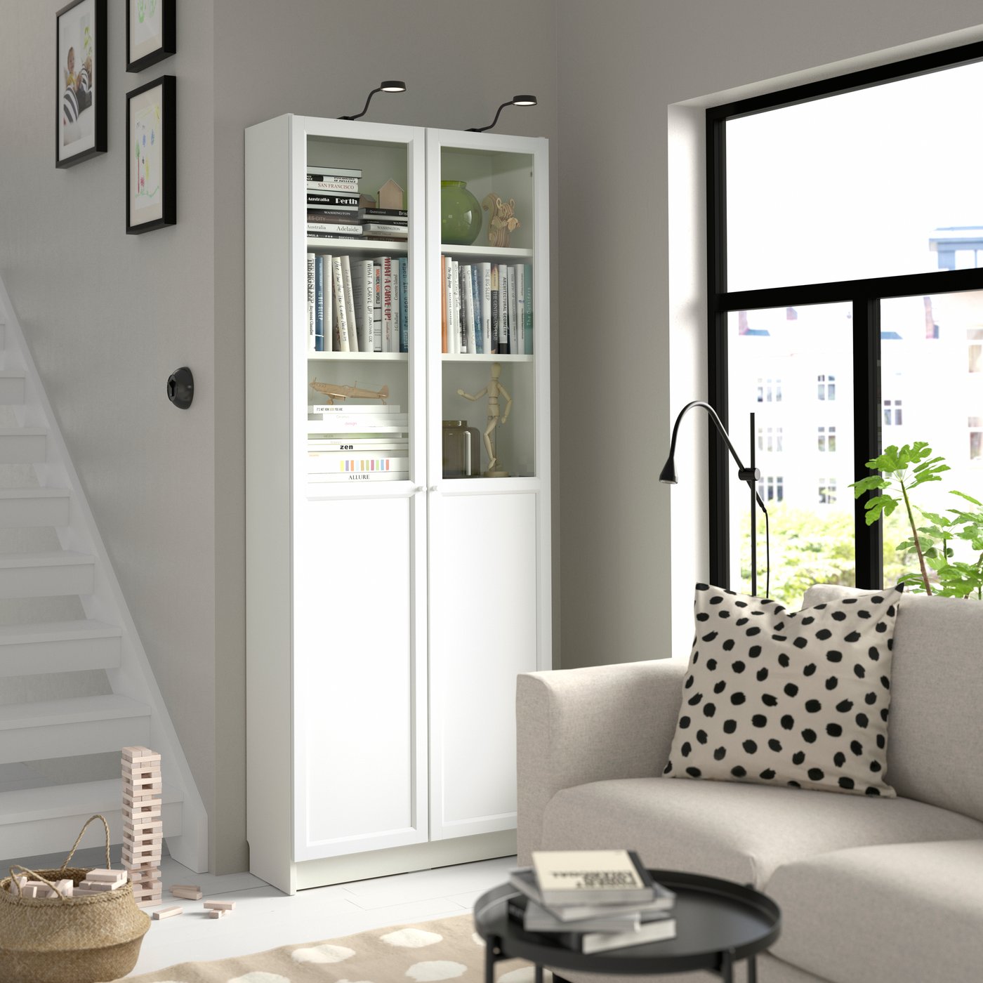 A white BILLY bookcase with panel/glass doors in the living room