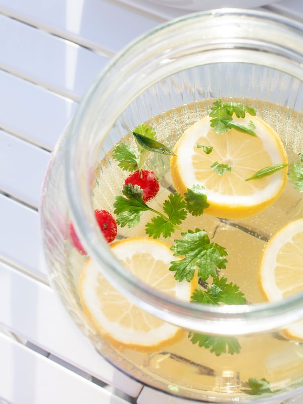 Midsommardrink med citrusfrukter serverad i en glasbehållare.