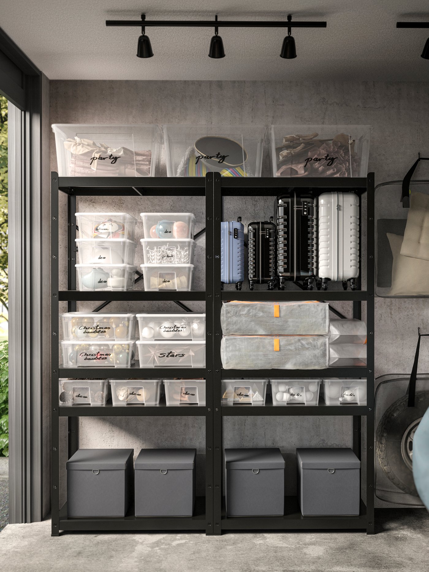 Une étagère en métal noir dans un garage ou débarras est remplie de bacs en plastique transparents et de trois grands bacs gris en bas.