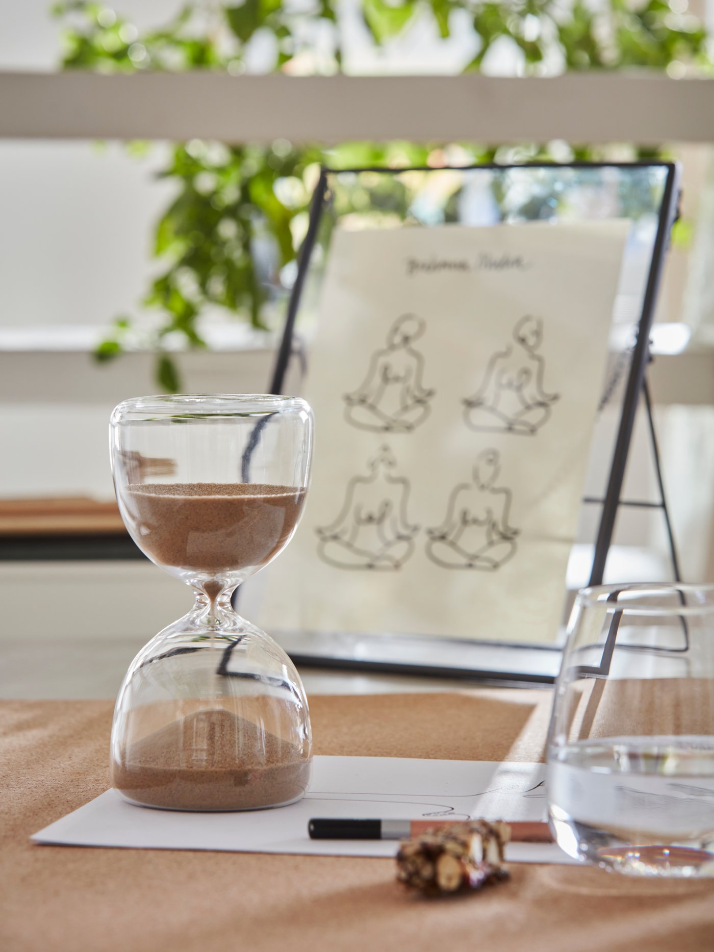 Glass decor items and framed botanical sketch placed on a wooden tabletop with sunlight filtering in – Decor from ₹399