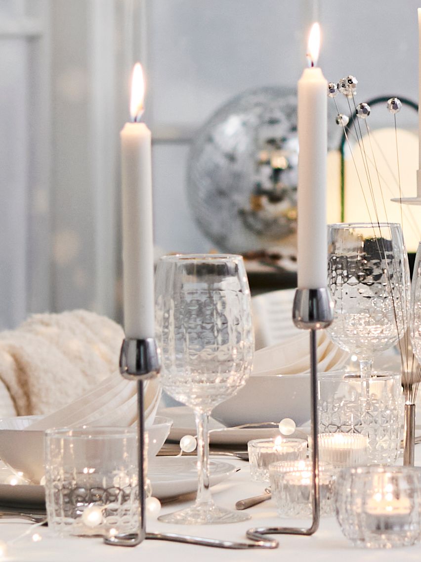 A clear glass FRÖJDA wine glass in the dining room