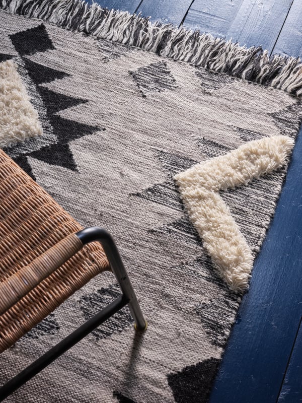 Vista superior de una alfombra TANNISBY y encima una silla ULRIKSBERG.