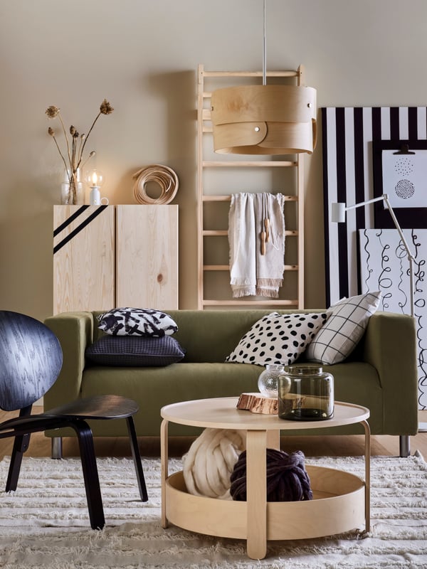 In a living room are a KLIPPAN sofa in green, birch IVAR cabinet and BORGEBY coffee table.