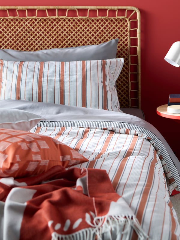 An orange PALPLJUNGMAL cushion cover in the bedroom