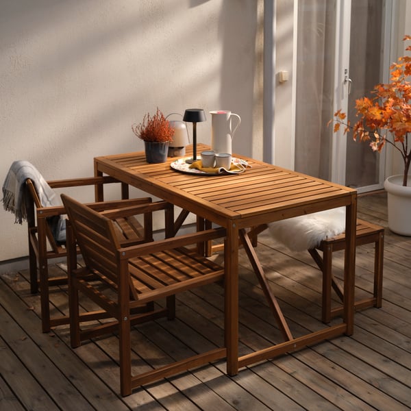 NÄMMARÖ chairs with armrests and a NÄMMARÖ bench with an ULLERSLEV sheepskin on it stand at a NÄMMARÖ table.