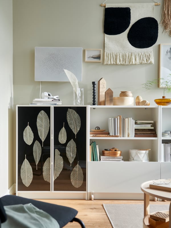 A light living room corner dominated by a row of white BILLY bookcases, one of which has personalised HÖGBO doors.