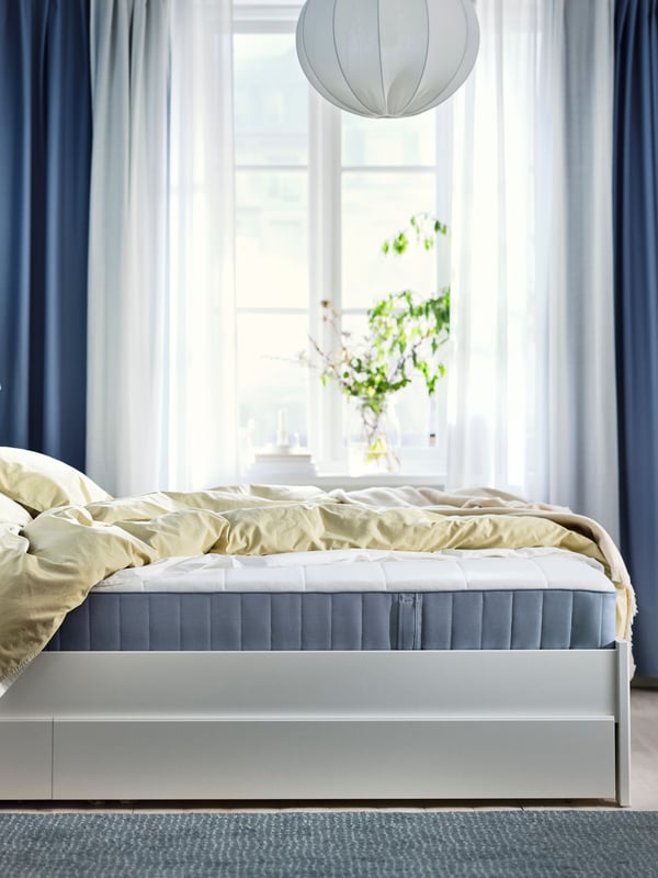 An extra firm/light blue VESTERÖY pocket sprung mattress in the bedroom