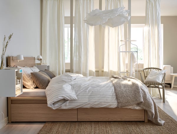 A white stained oak veneer MALM bed frame, high, w 4 storage boxes in the bedroom