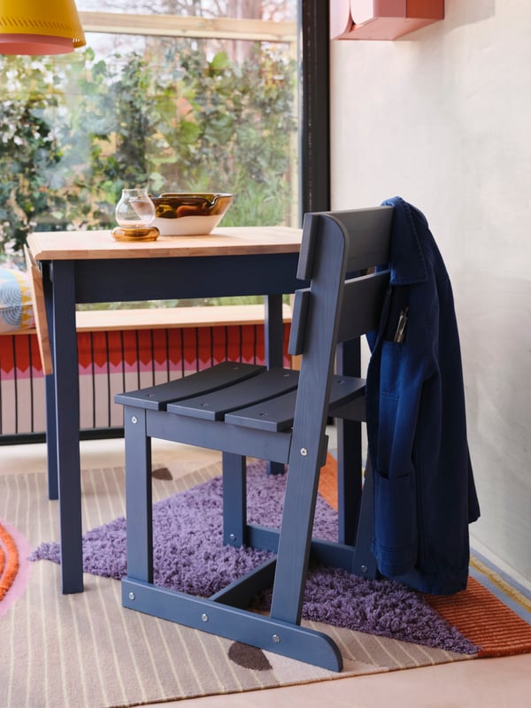 A pink orange/stained OMMJÄNGE cabinet w 2 doors and 1 shelf in the dining room