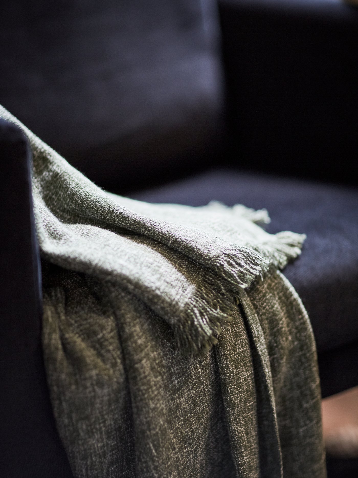 A close-up of an INGRUN throw on a KOARP armchair.