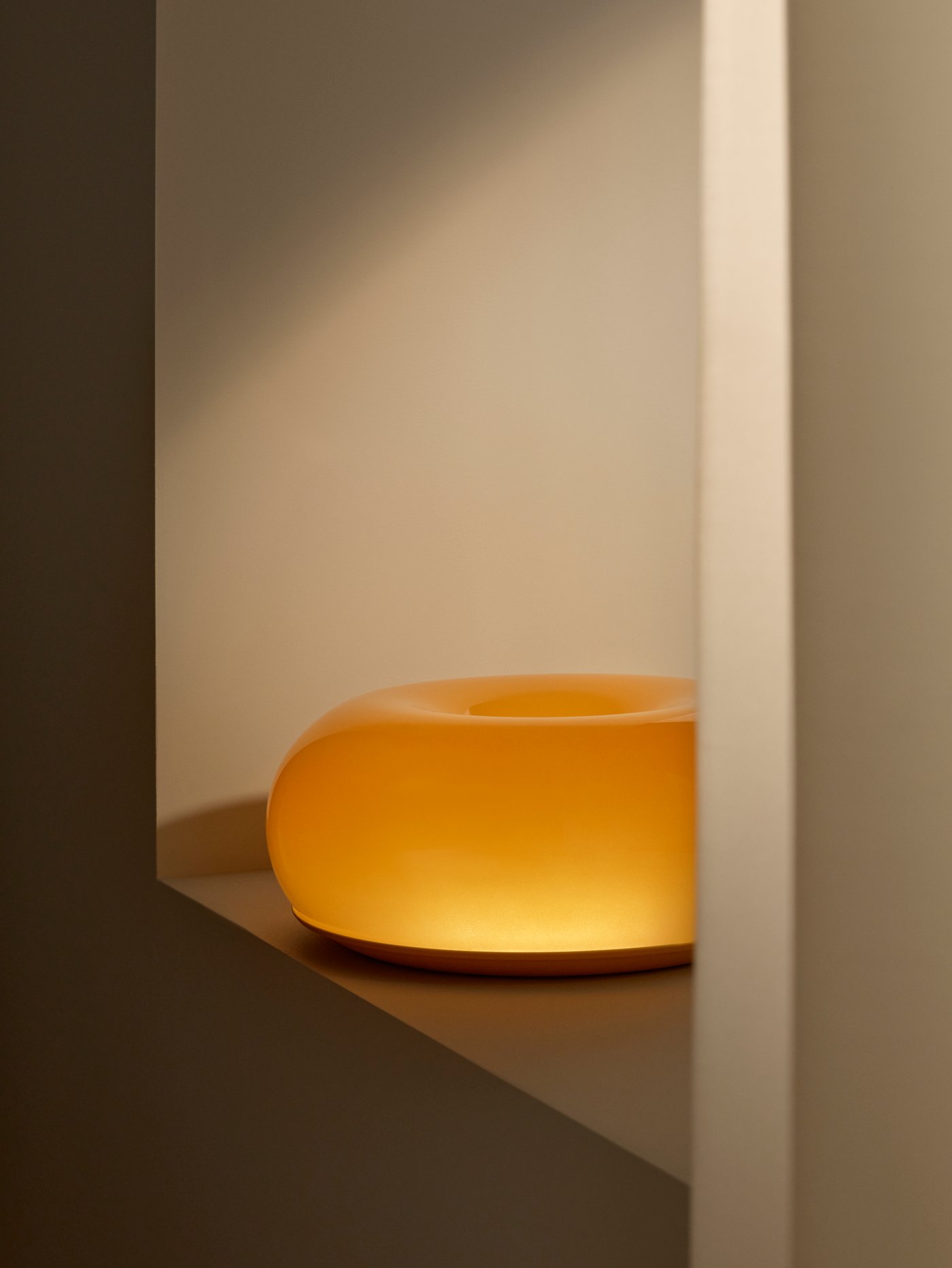 En orange, rund VARMBLIXT LED-bord-/vägglampa i glas.