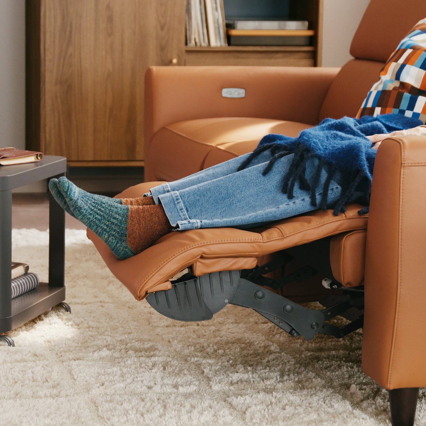 A Grann/Bomstad golden-brown RULLERUM 2-seat sofa with electric recliner in the living room