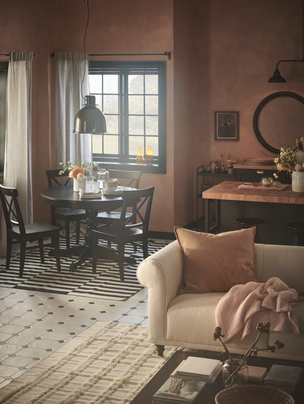 A rustic-style open-plan room contains traditional-style furniture in the dining, living, and kitchen areas.