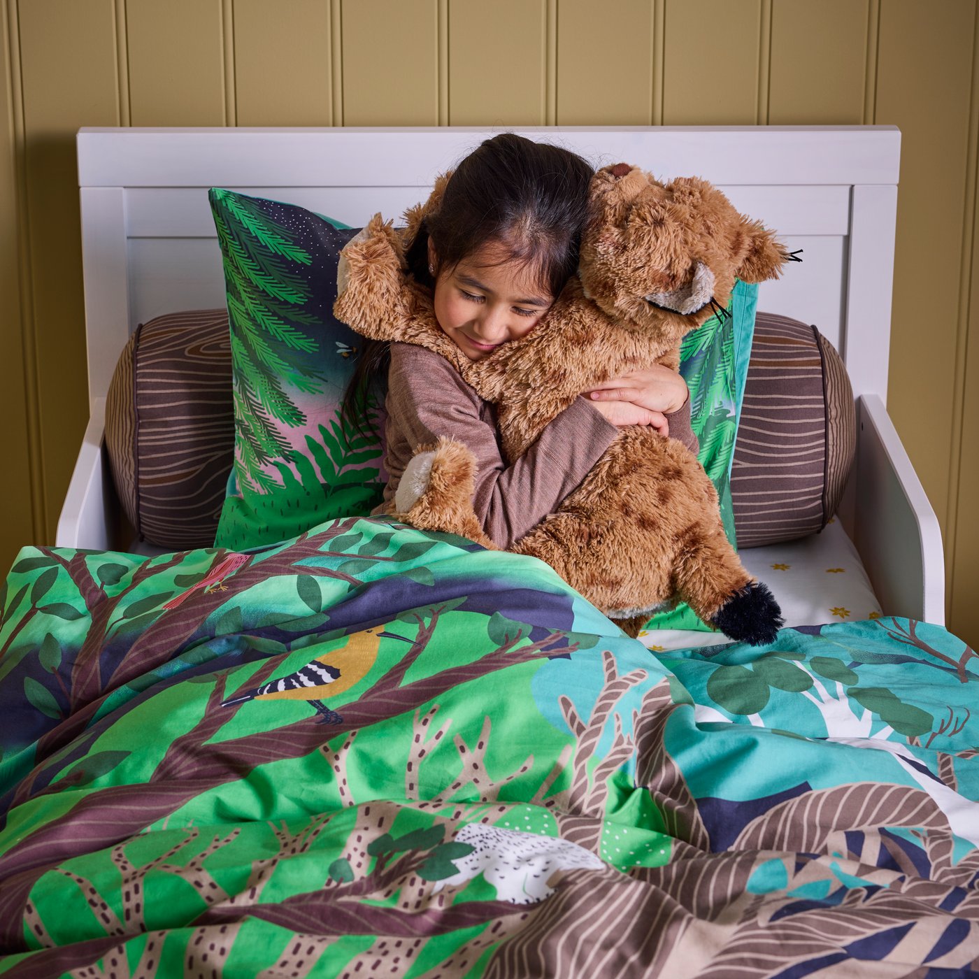 A cylinder shaped/brown SKOGSDUVA cushion in the childrens room