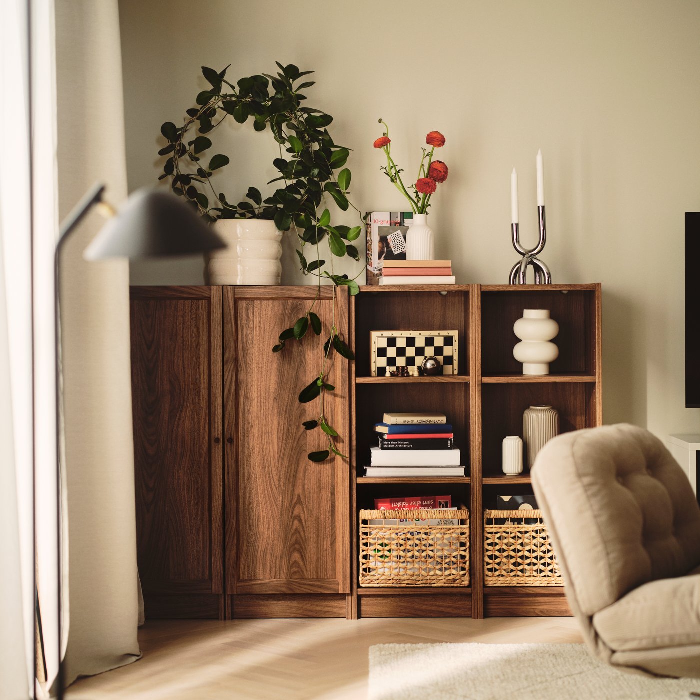A living room features a brown BILLY bookcase with a brown walnut effect, neatly displaying books and decorative items.