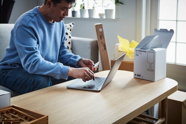 Deux clients sont conseillés par une employée IKEA