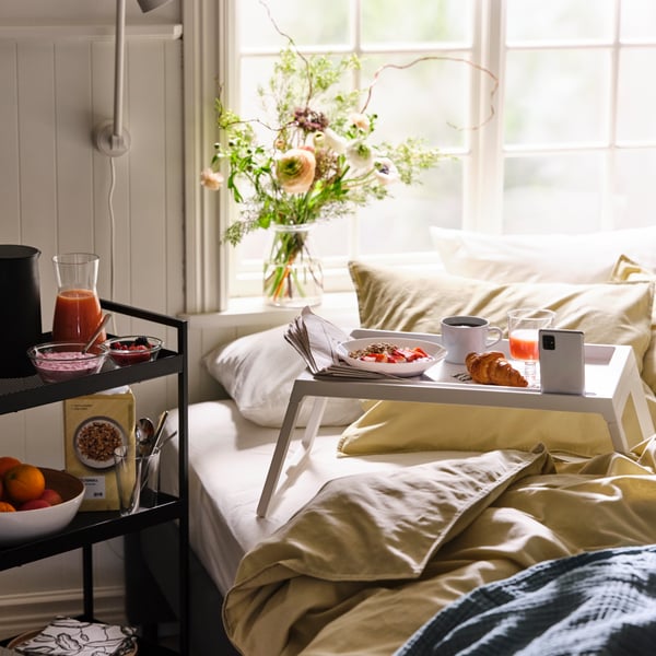A white KLIPSK bed tray in the bedroom