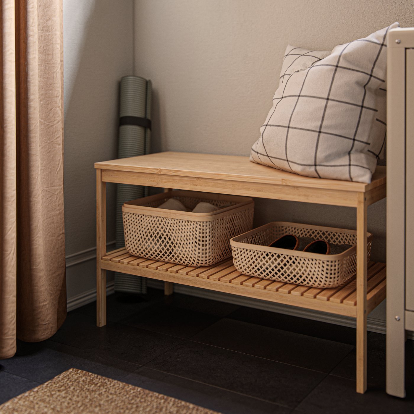A RÅGRUND bench in natural bamboo with a pillow on the top shelf and two small bamboo storage boxes on the lower shelf.