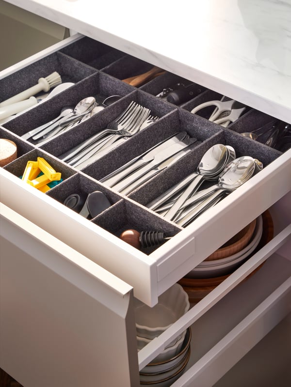 Laci dapur terbuka dengan penyusun boleh laras untuk laci UPPDATERA untuk laci di dalamnya, dipenuhi dengan kutleri dan perkakas dapur lain.