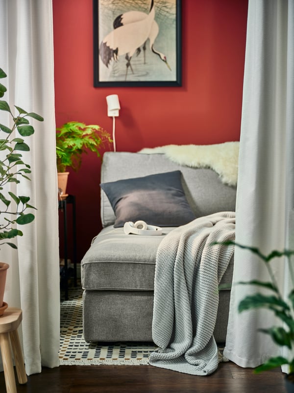 Curtains hanging in front of a grey sofa