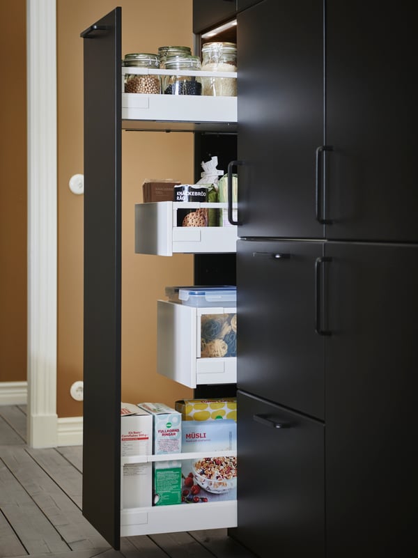 A dark, drawn-out, high kitchen front with multiple kitchen drawers filled with pantry-compatible containers and food.