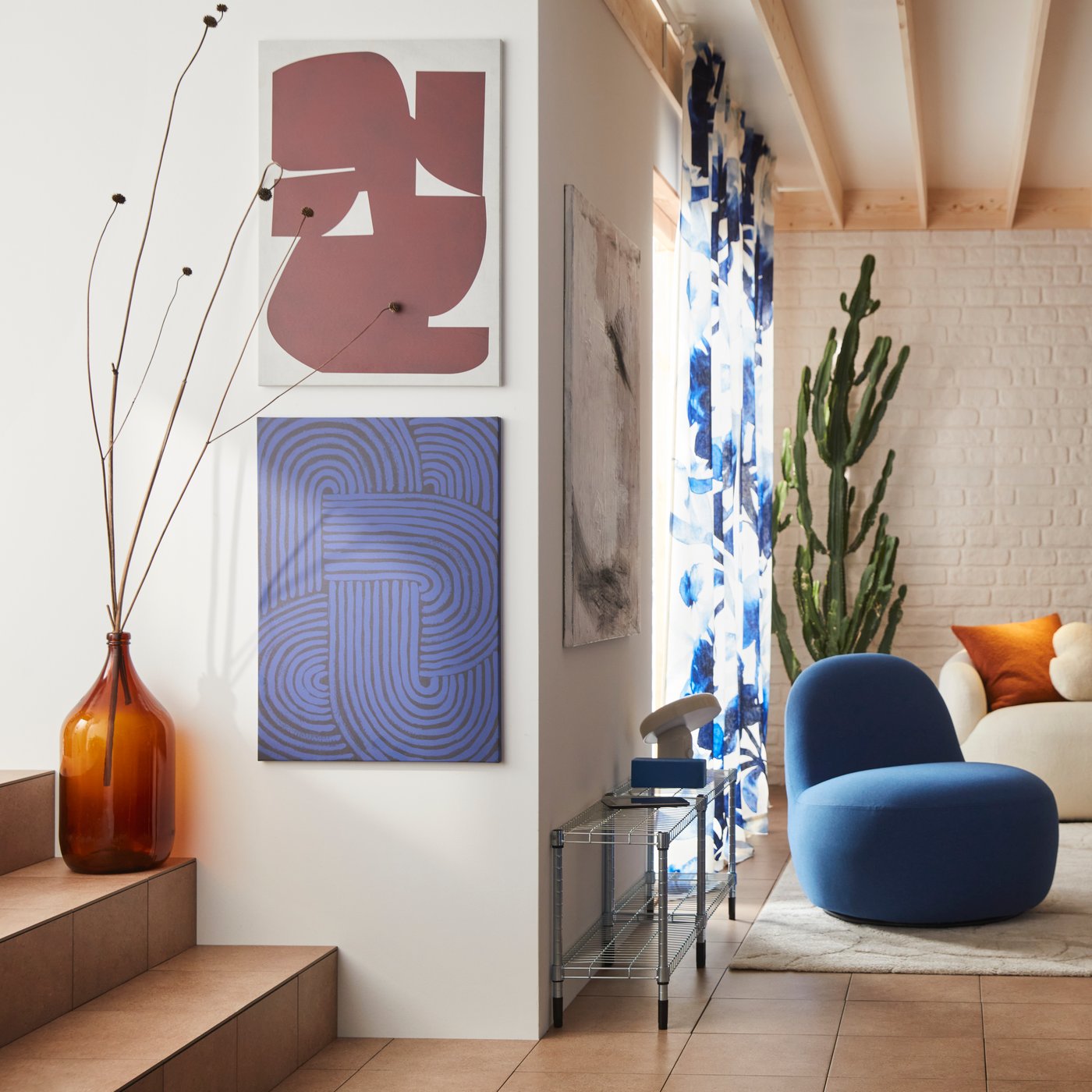 Un salon avec fauteuil relax pivotant LILLESÄTER revêtu d’un tissu Gunnared bleu foncé, à côté de deux cadres PJÄTTERYD.