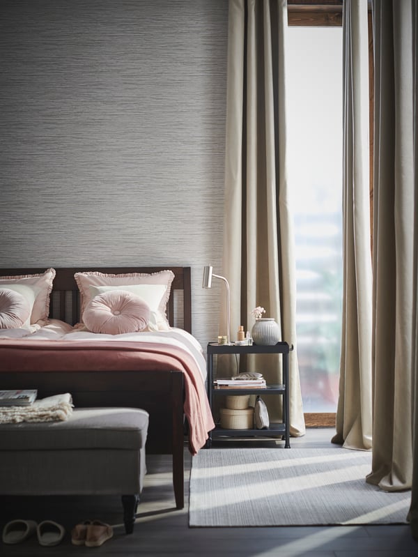 BIRTNA block-out curtains in the bedroom with a dark brown IDANAS bedframe, and KORNSJO bedside table nightstand.