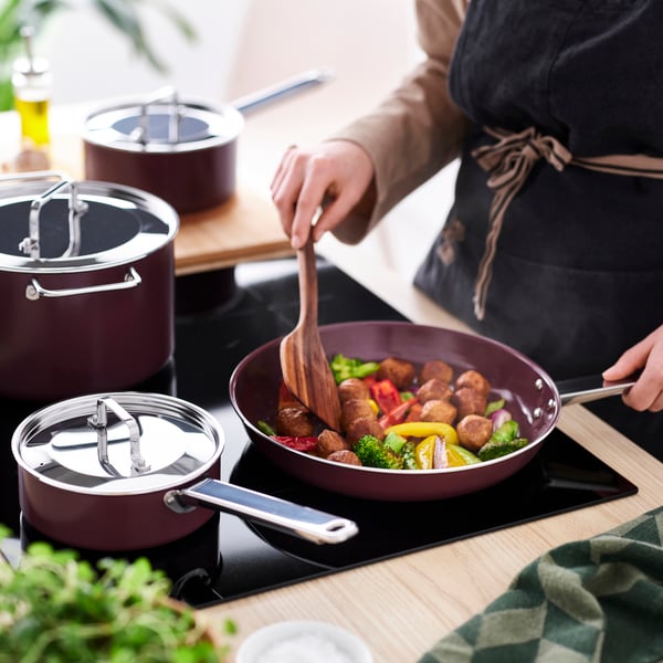 A non-stick coating stainless steel/dark red GULDÖRING 7-piece cookware set in the kitchen