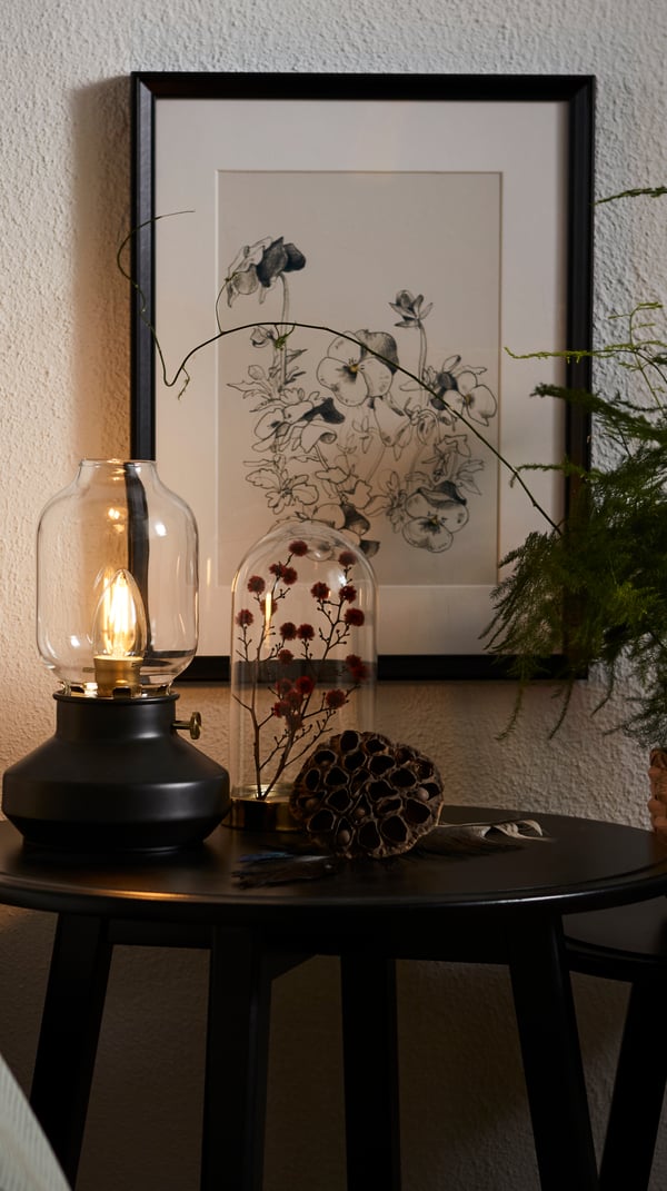 Une petite table d'appoint avec une lampe de table à l'ancienne. 