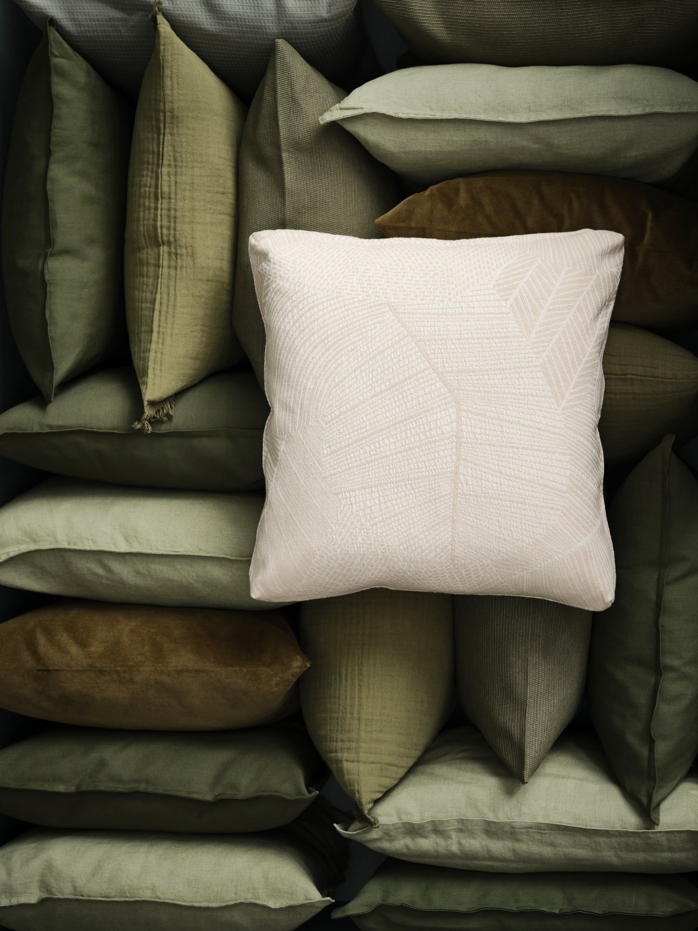 An off-white JÄTTEGRAN cushion cover
