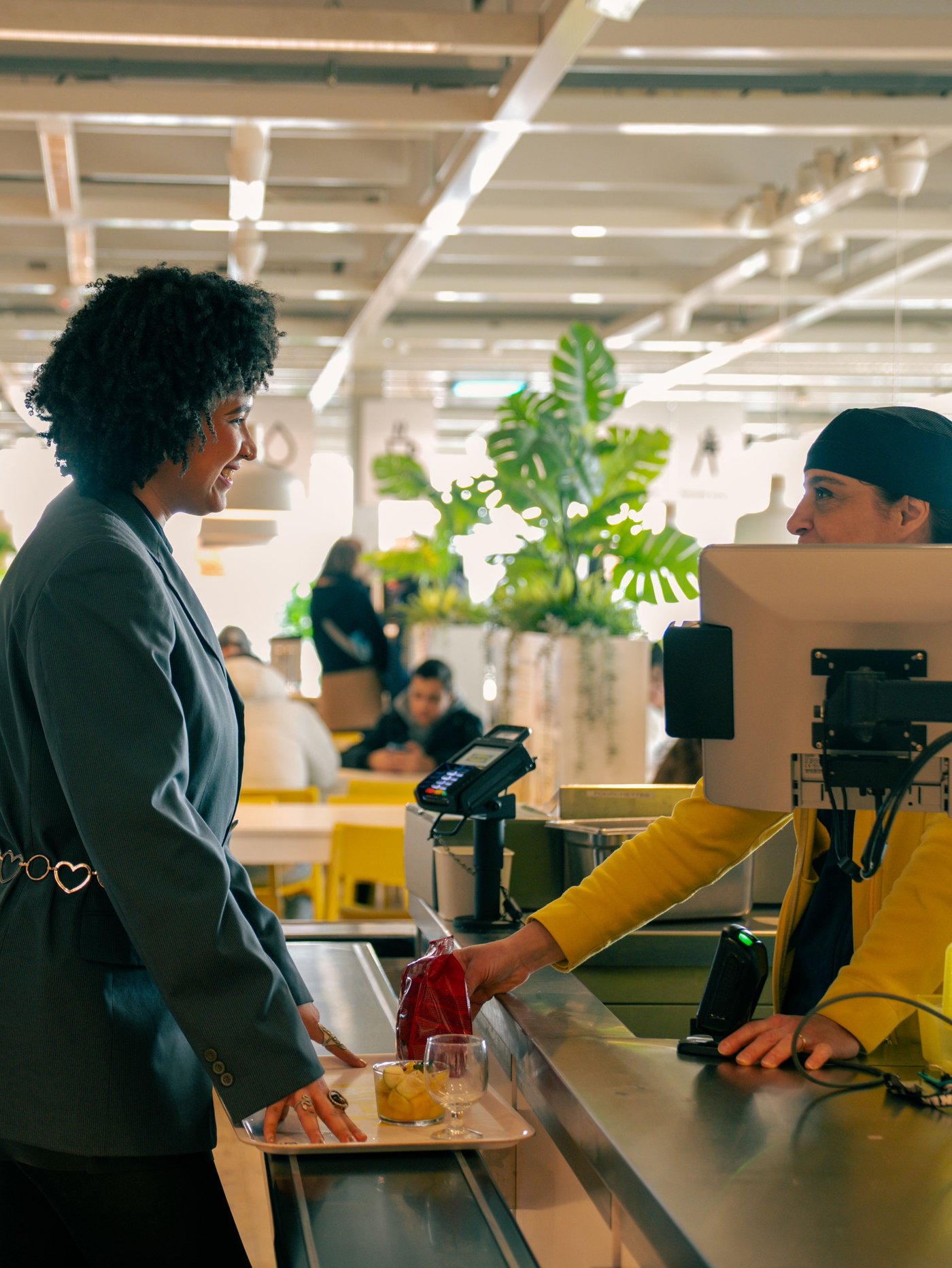 Shadia discutant avec une collègue à la caisse du restaurant d’un magasin IKEA.