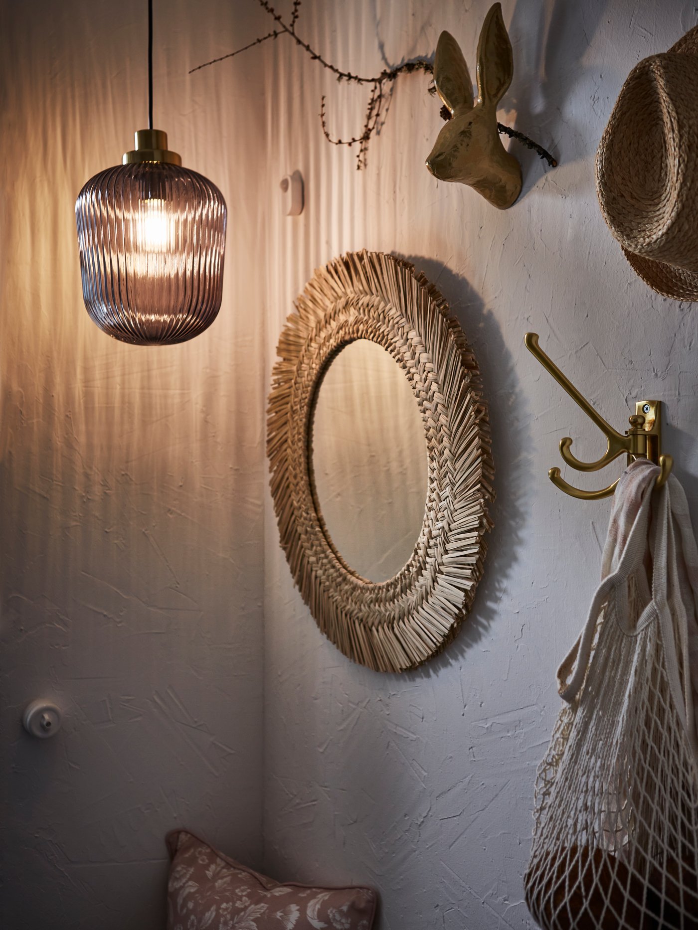 Pared con diversos elementos decorativos, un espejo de pared VRIGSTAD, una lámpara colgante SOLKLINT y un gancho giratorio 3 brazos KÄMPIG.