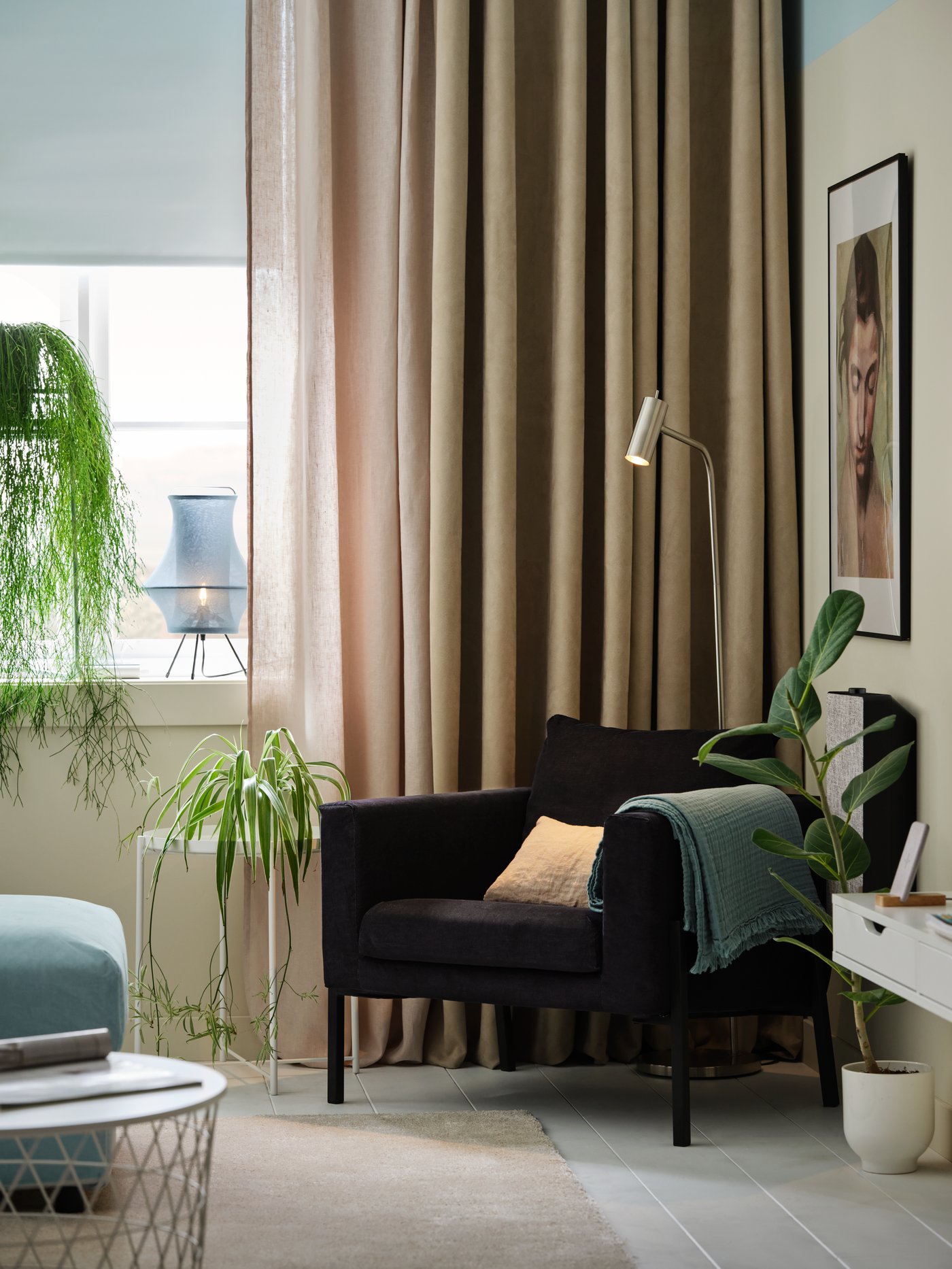 La esquina de un living con un sillón KOARP y detrás una ventana con tres capas de cortinas IKEA.