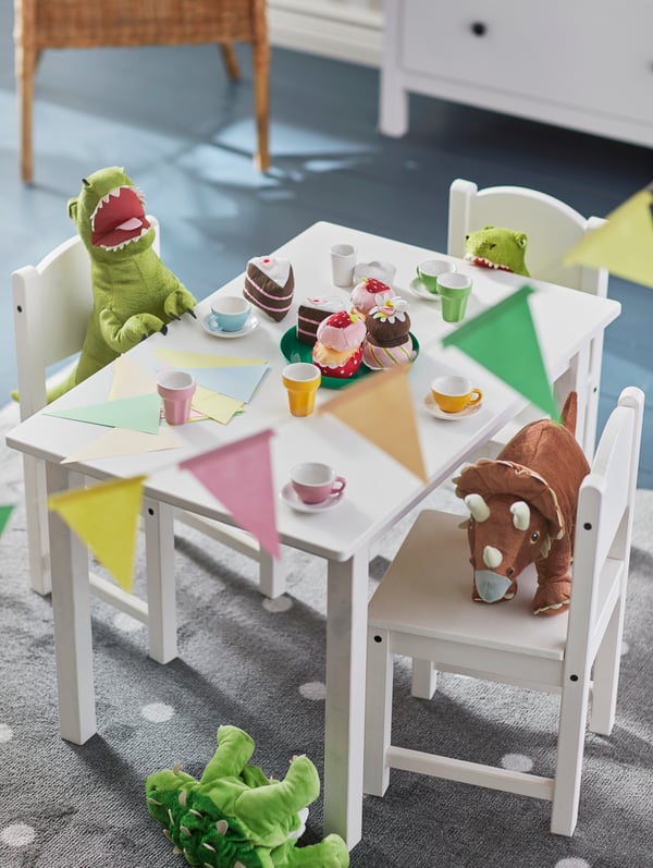 Una habitación infantil con una mesa pequeña SUNDVIK. Sobre ella hay peluches y accesorios infantiles. 