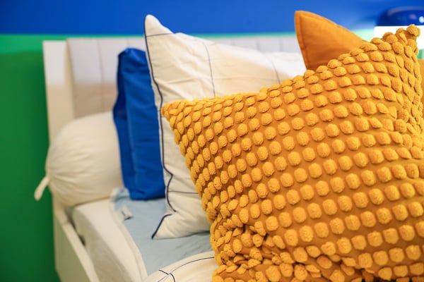 An yellow SVARTPOPPEL cushion cover