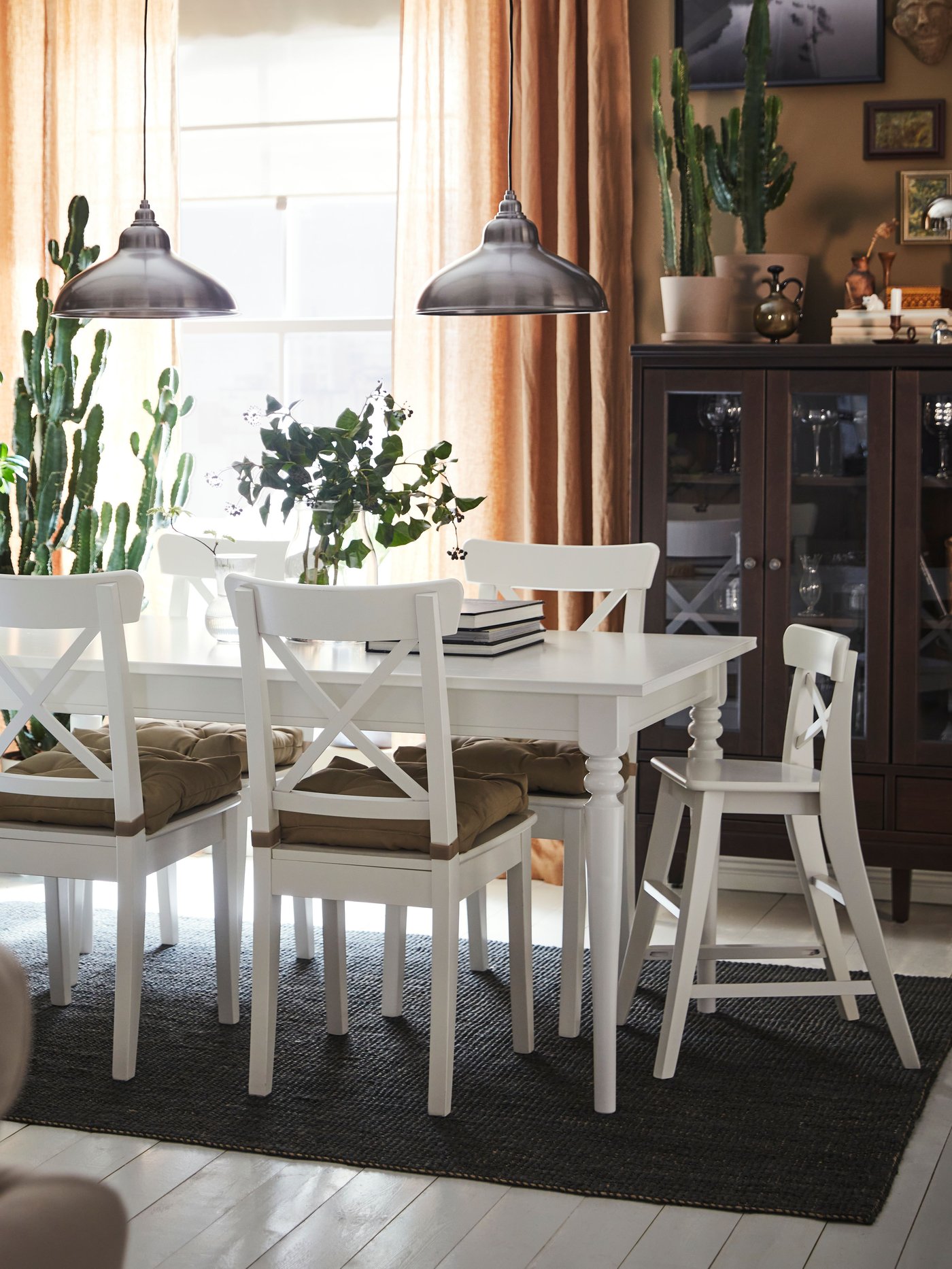 A white INGATORP extendable table, four INGOLF chairs and an INGOLF junior chair stand in a traditional-style dining area.