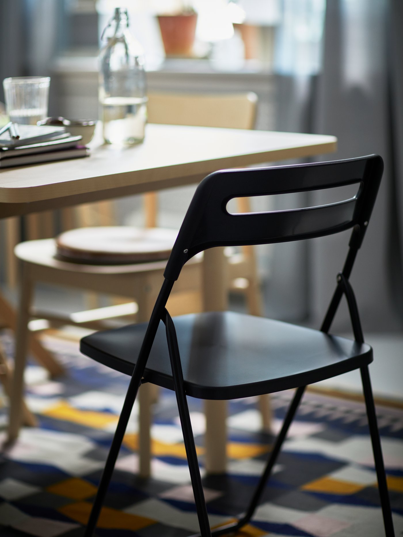 A black NISSE folding chair in the dining room