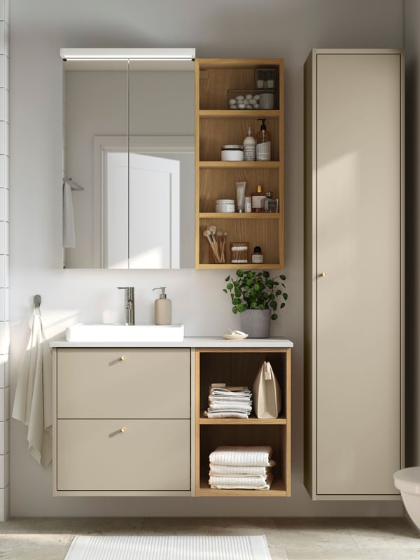 A beige HAVBÄCK wash-stand with drawers, an ORRSJÖN semi-recessed wash-basin and a mirror cabinet against a tiled wall.