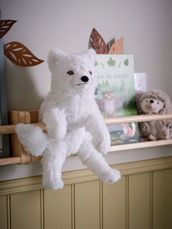 A SKOGSDUVA arctic fox soft toy and a SKOGSDUVA hedgehog soft toy are placed on a FLISAT wall storage.