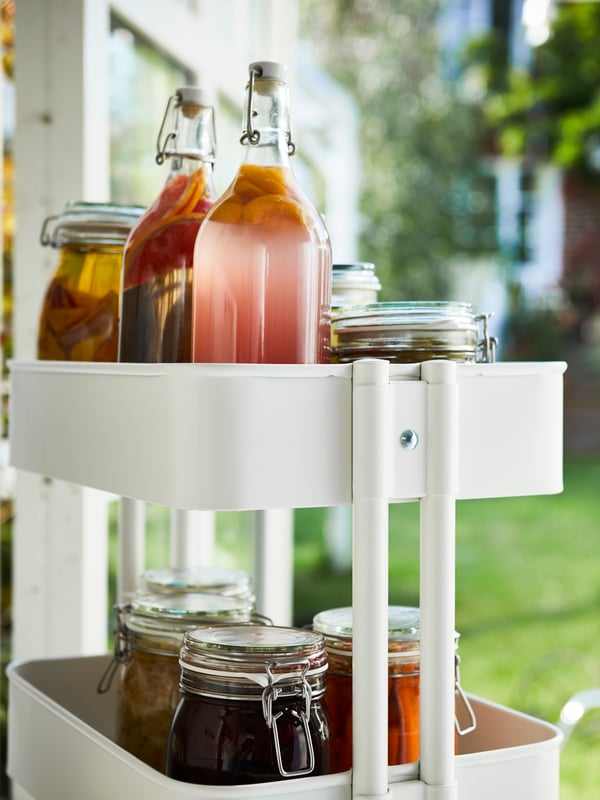 Kitchen worktop with plant pots and two KORKEN glass bottles, mid-session of infusing rapeseed oil with spices and herbs.