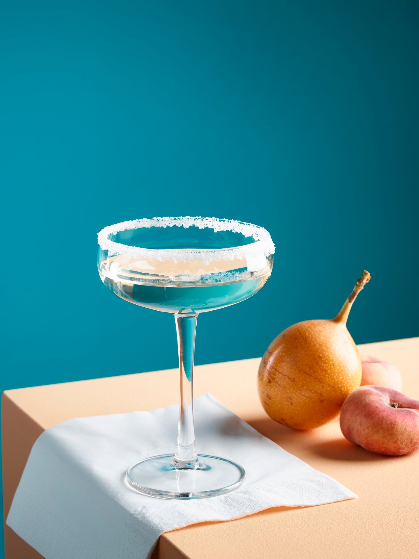 Copa de martini STORHET sobre una servilleta blanca y junto a verduras en una mesa.
