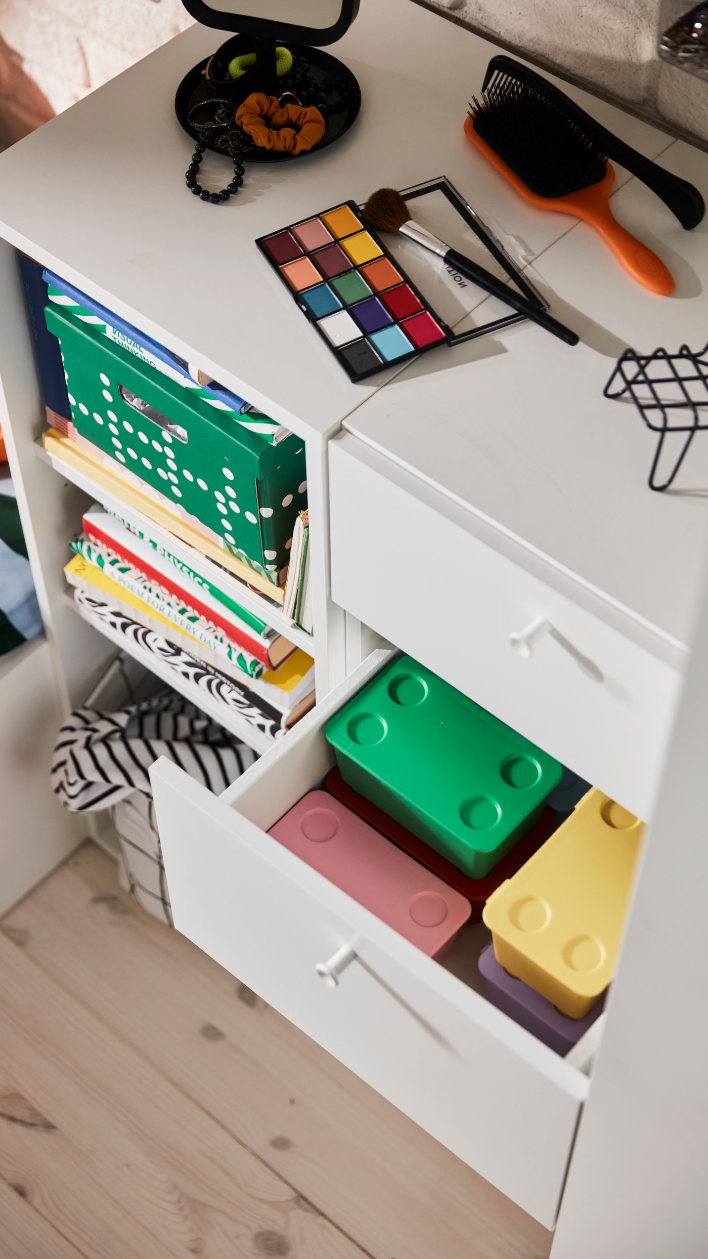A green/dotted FJÄDERHARV storage box with lid in the bedroom