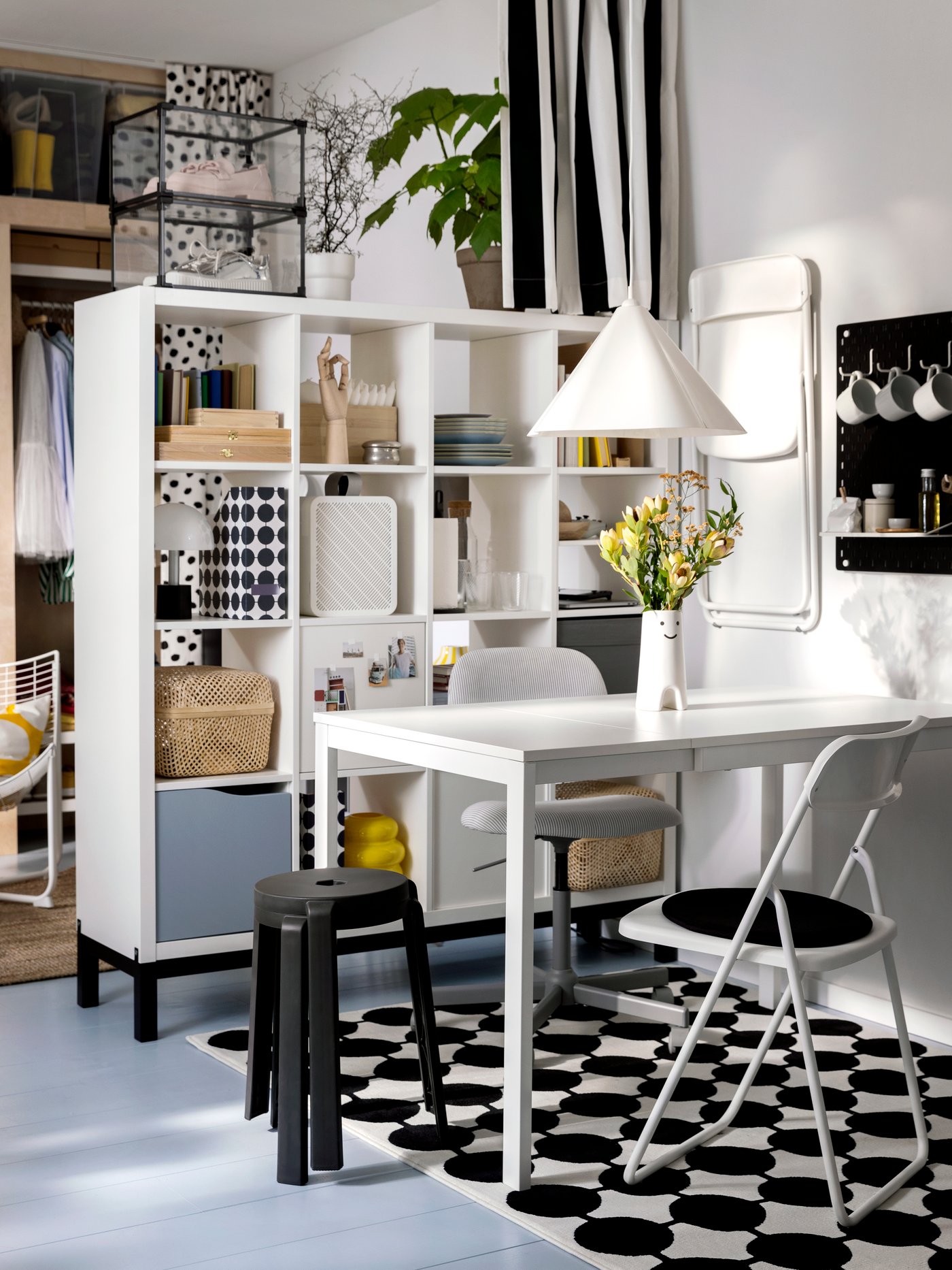 A swivel chair, a VIHALS folding chair and two stacked stools stand at a VIHALS extendable table in a small dining room area.
