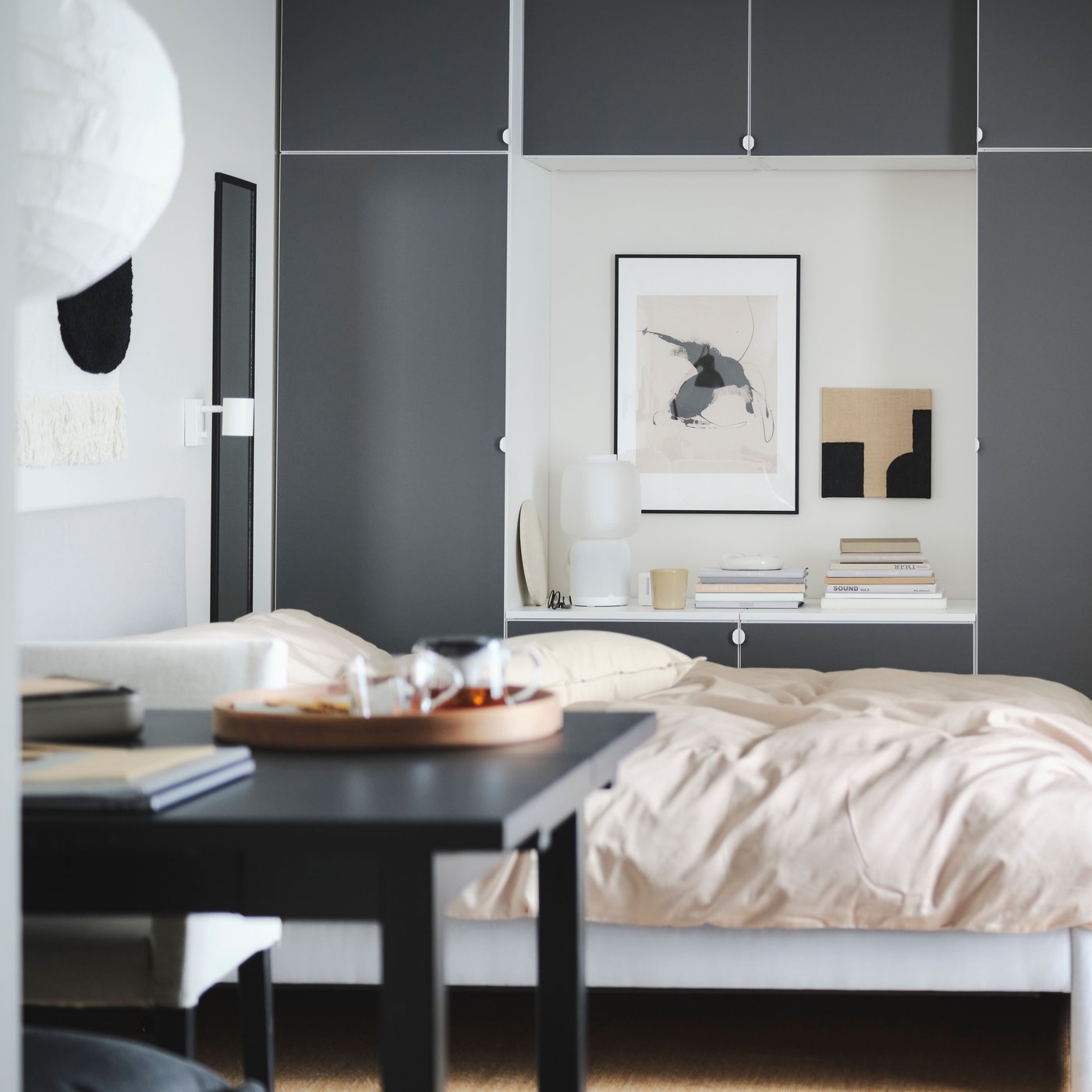 A calm bedroom with a bed, wardrobe and a table. 